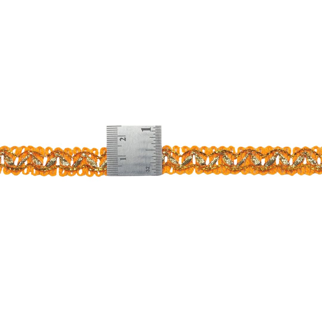 Decorative orange lace trim with a ruler for scale on a white background